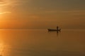 Fisherman at the boat on golden sunset sea. beautiful and romantic sunset. silhouette of fishermen with his boat Royalty Free Stock Photo