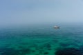 Fisherman boat on misty sea