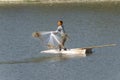 Fisherman on boat throwing stone