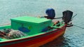 A fisherman boat waiting for the fisherman with ice box.