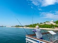 Fisherman on the bridge with a pier and jumping and walking people in Burgas, Bulgaria