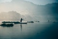 Fisherman casting out his fishing net in the river early in the blue colored morning to catch fish. Royalty Free Stock Photo