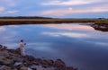 Fisherman catches fish at dusk on a break of river in forest. Dark gloomy photo. USA. Maine. fishing in the USA.