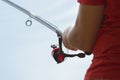 Fisherman catches a fish. Hands of a fisherman with a spinning rod in hand closeup. Spin fishing reel Royalty Free Stock Photo