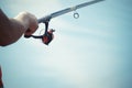 Fisherman catches a fish. Hands of a fisherman with a spinning rod in hand closeup. Spin fishing reel Royalty Free Stock Photo