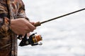 A fisherman catches a fish. Hands of a fisherman with a spinning rod in hand closeup Royalty Free Stock Photo