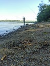 Fisherman catches fish rocky beach