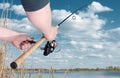 A fisherman catches a fish on spinning. Hands and coil closeup. Curved rod Royalty Free Stock Photo