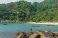 Fisherman catching fish on the rocky tropical beach in Thailand.