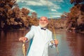 Fisherman caught a trout fish. Portrait of cheerful smiling angler senior man fishing. Grandfather with catch fish Royalty Free Stock Photo