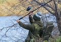 A fisherman in a chair on the river bank. Royalty Free Stock Photo