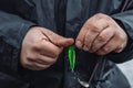 Fisherman changing spinner tail lure on spinning.