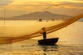 Fisherman checks his nets in early morning on river in Hoian, Vietnam Royalty Free Stock Photo