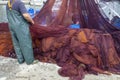 Fisherman cleaning nets and spread on the ground