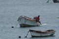 Fisherman climbing into boat using surfing board in Sal Rei, Cabo Verde