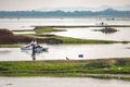 Fisherman coming back to the shore on his makeshift boat on a hazy summer day Royalty Free Stock Photo