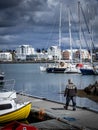 Fisherman dressed in an celandic wool sweater, walking down the pier, Hafnafjordur, Iceland.