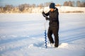 A fisherman drills a hole in the ice to catch fish, Tom river in Kemerovo, Russia Royalty Free Stock Photo