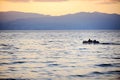Fisherman driving a boat on Ohrid Lake at sunset