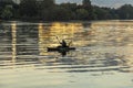 fisherman in early morning light fishes with his canoe at river colorado with golden sunrise reflections Royalty Free Stock Photo