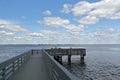 Fisherman at the end of a fishing pier overlooking a seascape.