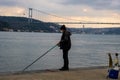 fisherman fishes on Bosphorus Istanbul on a Foggy sunrise