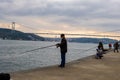 fisherman fishes on Bosphorus Istanbul on a Foggy sunrise