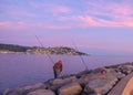 Fisherman fishes from a pier in the bay