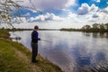 Fisherman fishes spinning on the river bank Royalty Free Stock Photo