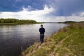 Fisherman fishes spinning on the river bank Royalty Free Stock Photo