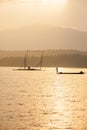 Fisherman on fishing boat in The Sirikit Dam, raft dip net and sunset sky backgrounds. Golden sun setting shines down around the