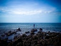 Fisherman Fishing In The Distance The Rocky Seashore At Umeanyar Village