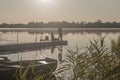 Fisherman fishing in foggy morning. Man silhouette resting with rod on river or lake in mist Royalty Free Stock Photo