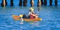 Fisherman with fishing gear paddling a Kayak.