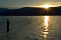 Fisherman fishing in McDonald lake in Glacier National Park at sunset Royalty Free Stock Photo