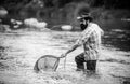 Fisherman fishing on a rever. Relaxed fisher man with a fishing rod on a summer day. Royalty Free Stock Photo