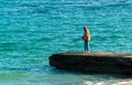 a fisherman with a fishing rod catches fish on a concrete pier in Odessa, Ukraine