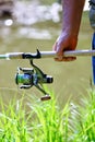 A fisherman with a fishing rod. Close-up of a hand holding spinning rod Royalty Free Stock Photo