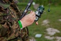 A fisherman with a fishing rod. Close-up of a hand holding a spinning rod and twisting a coil. Colorful view, blurred background, Royalty Free Stock Photo