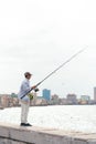 Fisherman with fishing rod on the concrete embankment of the Caribbean