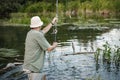 Fisherman with fishing rod near the lake at summer