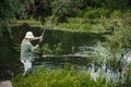 Fisherman with fishing rod near the lake at summer