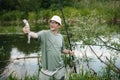 Fisherman with fishing rod near the lake at summer