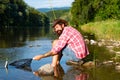 A fisherman with fishing rod on the river. Brown trout fish. Summer holidays and people concept. Trout. Trout on a hook Royalty Free Stock Photo