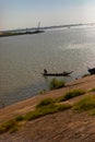 Fisherman fishing from a small wooden boat on the Mekong river Royalty Free Stock Photo