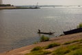 Fisherman fishing from a small wooden boat on the Mekong river Royalty Free Stock Photo