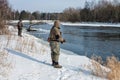 Fisherman fishing on a snowy winter river