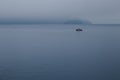 Fisherman fishing in speed boat, The boat floating in Toya Lake surrounded with fog in cloudy day at Japan. Royalty Free Stock Photo