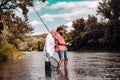 Fisherman fishing with spinning reel. Father and son fishing. Young man and old mature man fly fishing. Fishermen with Royalty Free Stock Photo