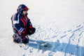 A fisherman is fishing with a winter spinning rod on a frozen lake Royalty Free Stock Photo